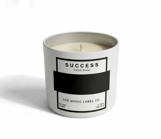 Success Candle from the magic label co. in a white container and the label is inactive hiding the message 